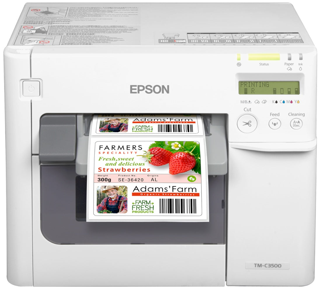 An Epson TM-C3500 label printer shown in a clean studio shot, printing a custom retail label featuring strawberries and the brand name 'Adams Farm'.